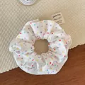 Detail of white chiffon scrunchie with colorful polka dots on a woven mat - Colorful Polka Dot Scrunchie