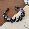 Dettaglio cerchietto punk con tessuto floreale viola e punte a cono nere lucide - Stile Floreale Nero e Viola con Punte / Nero
