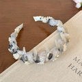 Dettaglio del cerchietto in rete intrecciata con perle e paillettes dorate su libro antico - Stile Floreale Bianco Sporco con Perle / Bianco Sporco
