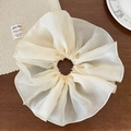 Detailed texture of an oversized beige organza lace scrunchie with soft ruffled edges - Beige
