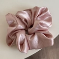Detailed view of large pink satin scrunchie showing glossy texture and rich pleated design - Pink