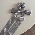 Detailed view of silver satin bow scrunchie with lace edges and long flowing ribbons - Ribbon Bow Scrunchie
