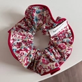 Detailed macro view of floral print scrunchie with red piping and hand made label - Spring Floral Red