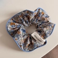Détail d'un chouchou à fleurs avec étiquette faite main et motifs floraux de couleur bleue - Floral Printemps Bleu