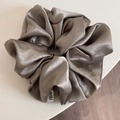 Close-up of elegant champagne satin oversized scrunchie with smooth silk texture - Brown