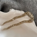 Dettaglio macro della forcina a U ondulata con trama in acetato marmorizzato su vassoio - Albicocca Beige