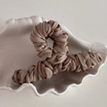 Close-up of elegant pleated champagne fabric wrapped hair claw clip on shell tray - Brown