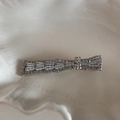 Dettaglio del fermaglio d'argento con strass a strati posizionato su un vassoio bianco - Clip di Strass Squisita-Nodo Asimmetrico