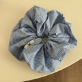 Gros plan d'un chouchou à rayures bleues et blanches avec de jolis plis et logo - Chouchou Rayé Bleu Foncé
