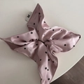 Detailaufnahme von rosa Satin-Haargummi mit schwarzen Blumenmustern und Stoffetikett - Rosa Aufdruck Band Scrunchie
