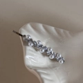 Detail of silver bow hair clip with white pearls and sparkling rhinestones on ceramic tray - Exquisite Rhinestone Clip-Pearl Tassel