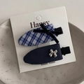 Detailed view of blue plaid and navy fabric hair clips with bow knots on a ceramic tray - Navy Blue Plaid Seamless Pair Clips