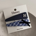 Close-up of blue plaid and navy bow hair clips on a white display card in a ceramic tray - Navy Blue Plaid Triangle Pair Clips