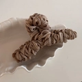 Detail of elegant coffee brown satin fabric pleated texture on a large hair claw clip - Brown