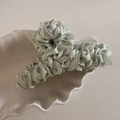Detailed view of large mint green pleated satin fabric wrapped hair claw clip for women - Green