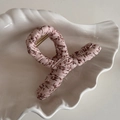 Gros plan d'une pince à cheveux en tissu fleuri avec motifs marron dans un plat coquillage - Rose Floral Forme X