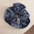 Dettaglio dell'elastico in denim blu a fiori con pois e un'etichetta in tessuto - Scrunchie plissettati / Blu scuro