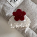 Detailed macro of medium acetate hair claw with white marble texture and red flower - White
