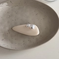 Detalle de pinza para el pelo crema con perlas sobre un plato de cerámica - Blanco Perla Francesa - Pinza de Gota