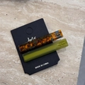 Detail of tortoise shell and olive green acetate hair clips set on marble surface - Green