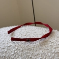 Detalle de la diadema de satén rojo con una placa de metal dorado grabada minimalista - Rojo