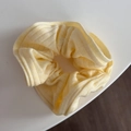 Detail of light yellow ribbed knit scrunchie with ruffled texture and elastic design - Striped Knit Scrunchie - Yellow