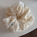 Macro detail of ivory organza scrunchie with delicate wavy embroidery and small logo tag - Neo-Chinese Embroidery Cream Scrunchie