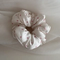 Detailansicht von beigem Satin-Haargummi mit rosa Punkten und weicher, glatter Textur - Beige