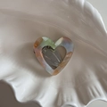 Vue rapprochée d'une pince à cheveux cœur en acétate avec motif marbré et plateau - Cœur Orange Vert