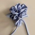 Vue détaillée du chouchou en satin bleu lavande avec de longs rubans fluides élégants - Bleu