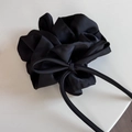 Détail d'un chouchou en satin noir avec un long ruban montrant sa texture soyeuse - Noir