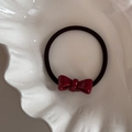 Detail van zwarte haarelastiek met wijnrode acetaat strik op wit schelp porselein - Strik decoratie / Rood