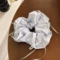 Primer plano de coletero azul cielo con lazos blancos sobre fondo de mesa de madera oscura - Azul