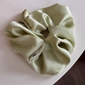 Détail du chouchou en satin vert menthe avec strass et étiquette de logo - Vert
