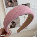 Detailansicht eines rosa gestrickten breiten Haarreifs mit dicker, gepolsterter Textur - Rosa