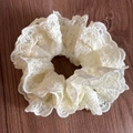 Close-up of beige lace scrunchie with layered embroidery details on dark wood table - Heavy Embroidery Beige Lace