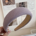 Detailstruktur des lila gestrickten breiten Stirnbands mit weicher Polsterung und Futter - Lila
