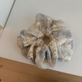 Vista detallada del elegante coletero de organza azul con bordado floral blanco - Azul