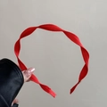Detailed close-up of a vibrant red ribbed fabric headband with elegant gold metal tips - Red