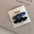 Detail of two denim heart hair clips on display card with white printed patterns - Long Oval Style / Denim Blue