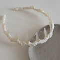 Detail of cream knitted headband featuring unique resin shark tooth accents on a ceramic plate - Lace Wrapped Headband