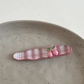 Detail der rosa karierten Haarspange mit Kirsch-Anhängern und Spitze auf Keramikteller - Kirschrosa-Clip - Welle