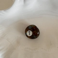 Detail view of small amber tortoiseshell acetate hair claw clip with black number 7 print - Round Style (FJ891721) / No.7 (Tortoiseshell)