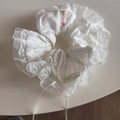 Dettaglio di elastico in pizzo bianco con fiocco in nastro ed etichetta fatta a mano - Stile Pizzo Base / Pizzo Bianco con Fiocco Bianco