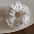 Dettaglio di un elastico in pizzo bianco con bordi smerlati e trama in organza - Stile Pieghettato Stretto / Organza Plissettata Bianca