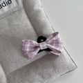 Dettaglio del fermaglio per capelli con fiocco a quadretti rosa su lino grigio - Piccola Molla con Fiocco Gingham / Rosa