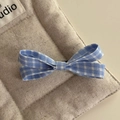 Close-up of blue and white gingham bow hair clip with textured fabric on linen - Gingham Bow Duckbill Clip / Blue