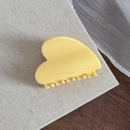 Détail d'une pince à cheveux jaune en forme de cœur sur fond de lin beige - Jaune Fromage Forme Cœur
