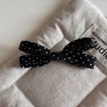 Close-up detail of a French style black and white polka dot bow hair clip on quilted fabric - Black Polka Dot - Bow Hair Clip