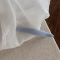 Detail view of a minimalist light blue hair claw clip with a glossy finish on white fabric - Light Blue Solid Willow Leaf Clip